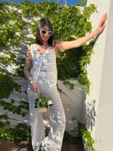 Conjunto de hilo blanco y beige, compuesto por un chaleco de punto calado con botones y un pantalón palazzo de punto calado.
