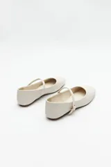 Balerinas color borgoña de cuero sintético texturizado, con tira sobre el empeine y hebilla metálica ajustable.