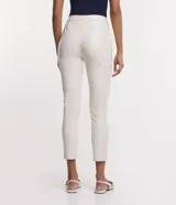 Pantalón legging de material sintético color gris topo, con cintura alta abotonada.