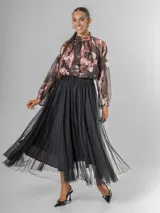 Falda estilo ballet core confeccionada en gasa negra con pequeños destellos que aportan brillo sutil y movimiento. Tiene cintura elastizada.