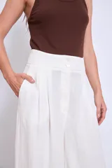 Pantalón palazzo de lino color crudo, con cintura alta y pinzas delanteras.