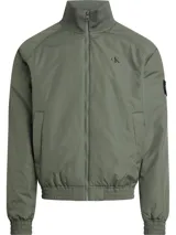 Campera bomber verde militar de poliéster reciclado, con cuello alto, puños y bajo elásticos. Cierre de cremallera, bolsillos ribeteados en la cintura y forro ligeramente acolchado. Logo de Calvin Klein en el pecho y la manga.