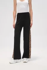 Pantalón negro de tejido de punto con corte ancho y cintura alta. Presenta una franja lateral con estampado animal print.