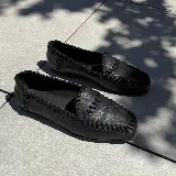 Mocasines negros de cuero vacuno con tientos de cuero pasados a mano y suela de goma.