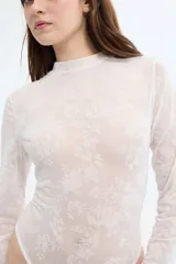 Body blanco de encaje con cuello alto y mangas largas.