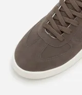 Championes marrones de material sintético con efecto gamuza, cierre con cordones, suela blanca contrastante y detalles de recortes.