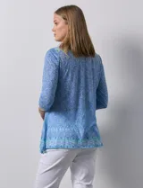 Blusa de modal estampado en tonos celeste, azul y verde, con aplique de brillos en el frente y mangas 3/4.