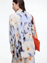 Camisa de manga larga confeccionada en viscosa crinkled con estampa de manchas. De silueta amplia y fluida, con bolsillos frontales grandes, tajos laterales y largo extendido en la espalda.