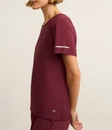Remera deportiva blanca texturizada, con cuello redondo, manga corta, detalle reflectante y pliegue en la espalda.