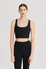 Top deportivo negro de cintura ancha, realizado en tela doble suave y de alta elasticidad. Detalle de breteles cruzados en la espalda.