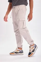 Pantalón cargo jogger gris claro con bolsillos laterales y tobillos ajustados.