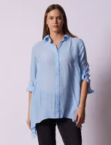 Camisa color beige claro, de corte recto y mangas 3/4 con botón para sujetar.
