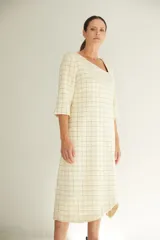 Vestido midi color crema con escote cuadrado, manga francesa con tajo y bolsillo lateral. Confeccionado en lana fina sin teñir.