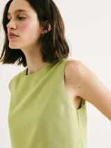 Blusa verde sin mangas, de corte recto y cuello redondo.