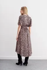 Vestido midi con estampado animal print, mangas cortas amplias, escote en V, cintura elastizada tipo nido de abeja, tajo central y ruedo asimétrico en picos.