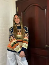 Sweater de lana merino con cuello redondo y diseño con motivos geométricos en tonos azul, marrón, naranja, verde y beige.