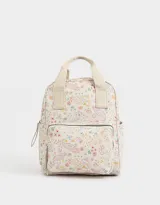 Mochila negra de cuerina con doble asa corta de mano con textura, correas regulables, cierre superior, bolsillo frontal con cierre, bolsillos laterales y tag en relieve.