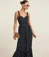 Vestido midi evasé sin mangas, confeccionado en tejido airflow con estampado de caracolas. Presenta escote corazón, breteles medianos con elásticos, recortes fruncidos en la cintura y en el bajo, y cierre lateral con cremallera invisible.