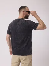 Remera azul con cuello redondo y tapeta con botones. Tiene un acabado desgastado.