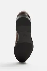 Zapato de vestir marrón tipo derby, con parte superior lisa, horma en punta y suela con ligero tacón.