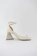 Sandalias negras de cuero sintético con punta cuadrada, tira delgada sobre los dedos y pulsera con hebilla al tobillo. Taco geométrico triangular. Marca Trend.