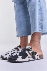 Zuecos con estampado de vaca en blanco y negro, con hebilla metálica ajustable y plantilla de corcho.