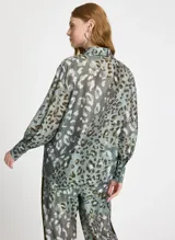 Camisa de manga larga con estampado animal print en tonos verde, marrón y blanco. Tiene cuello clásico, cierre frontal con botones y puños con tres botones.