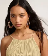 Vestido midi de jersey texturizado color verde oliva, con escote halter, espalda descubierta, breteles finos y tajo lateral.