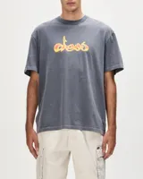 Remera gris de manga corta con cuello redondo y logo Deus en el pecho con tipografía estilo graffiti en amarillo y naranja.