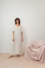 Vestido midi color crudo, de corte suelto, con escote en V y mangas abullonadas.