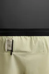 Shorts deportivos color gris oscuro confeccionados en tejido técnico ligero y elástico con forro interior, cintura elástica ajustable con cordón, bolsillos laterales, bolsillo de seguridad en espalda con cierre de cremallera, bajo con aberturas laterales y detalle de logo estampado en pernera.
