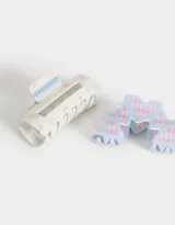 Set de dos broches para el pelo, uno tipo clip rectangular color crema con estampado de flores y cuadros celestes, y otro tipo clip con forma de arco con corazones y estampado de cuadros rosas y celestes.