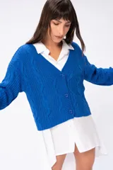 Saco tejido color marrón claro con diseño trenzado, escote en V y cierre frontal con botones marrones.