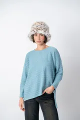 Sweater gris claro con textura acanalada horizontal, escote redondo y corte asimétrico. Detalle de lurex en la trama.