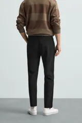 Pantalón largo de vestir gris claro con estampado de cuadros, corte slim fit y cintura elástica. Confeccionado en tejido con alta elasticidad, bolsillos frontales y cierre frontal con cremallera y botón.