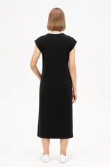 Vestido midi negro de algodón, corte holgado, manga corta y cuello redondo.