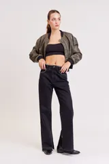 Pantalón de jean negro de corte ancho con aberturas en el ruedo y detalle de strass en la cintura y bolsillos.