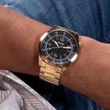 Reloj Guess modelo MAX con caja redonda de acero dorado de 42mm y esfera negra con números arábigos dorados. Correa de acero dorado con cierre de hebilla. Resistente al agua hasta 50 metros.