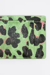 Tarjetero Bimba y Lola con estampado animal print en tonos lila, negro y naranja. Confeccionado en poliéster y poliuretano con logo metálico.
