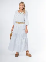 Falda larga de estilo campesino color crudo, confeccionada en algodón italiano con apliques florales al tono. Tiene cintura elastizada y cinto de rafia elastizado desmontable.