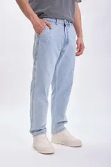 Pantalón de jean celeste, corte recto, estilo carpintero, con bolsillos laterales y traseros.