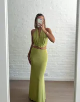 Conjunto verde de top halter con escote profundo y falda midi ajustada.