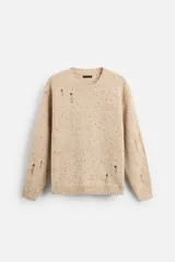 Sweater color beige con detalles de roturas y agujeros.