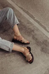 Sandalias color beige con tiras de cuero y ajuste con velcro, con base chunky negra.