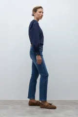 Jean slim de mujer color azul medio, con tiro medio y corte ajustado.