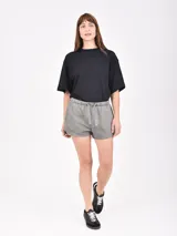 Short negro de tela suave con cintura elástica ajustable con cordón, bolsillos laterales y corte redondeado en los laterales.