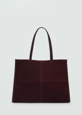 Bolso tipo shopper color bordó, confeccionado en cuero vacuno, con cierre de botón magnético, asa de hombro y bolsillo interior.