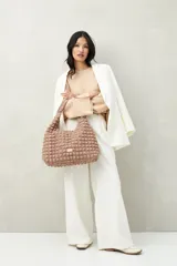 Sweater color beige de tejido de punto, con cuello redondo y mangas largas acampanadas con botones decorativos en los laterales.