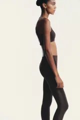 Top negro con escote redondo, tirantes finos ajustables y tejido combinado en tul a tono. Cierre en espalda con gancho metálico.