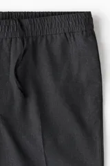 Pantalón sastrero tobillero color gris oscuro, corte slim fit, con elástico en la cintura, bolsillos laterales y traseros ribeteados.
